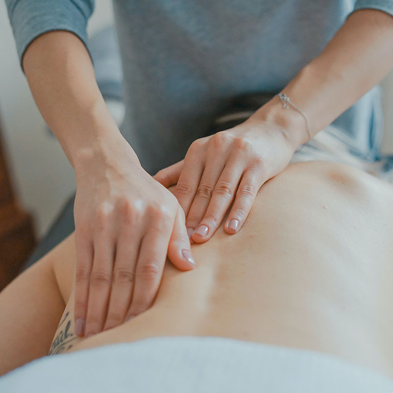 Massage therapist massaging someone's lower back
